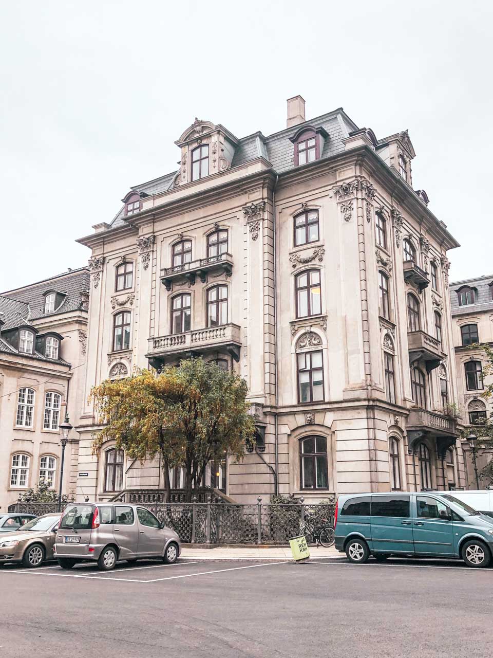 A building in Copenhagen, Denmark with some cars parked outside