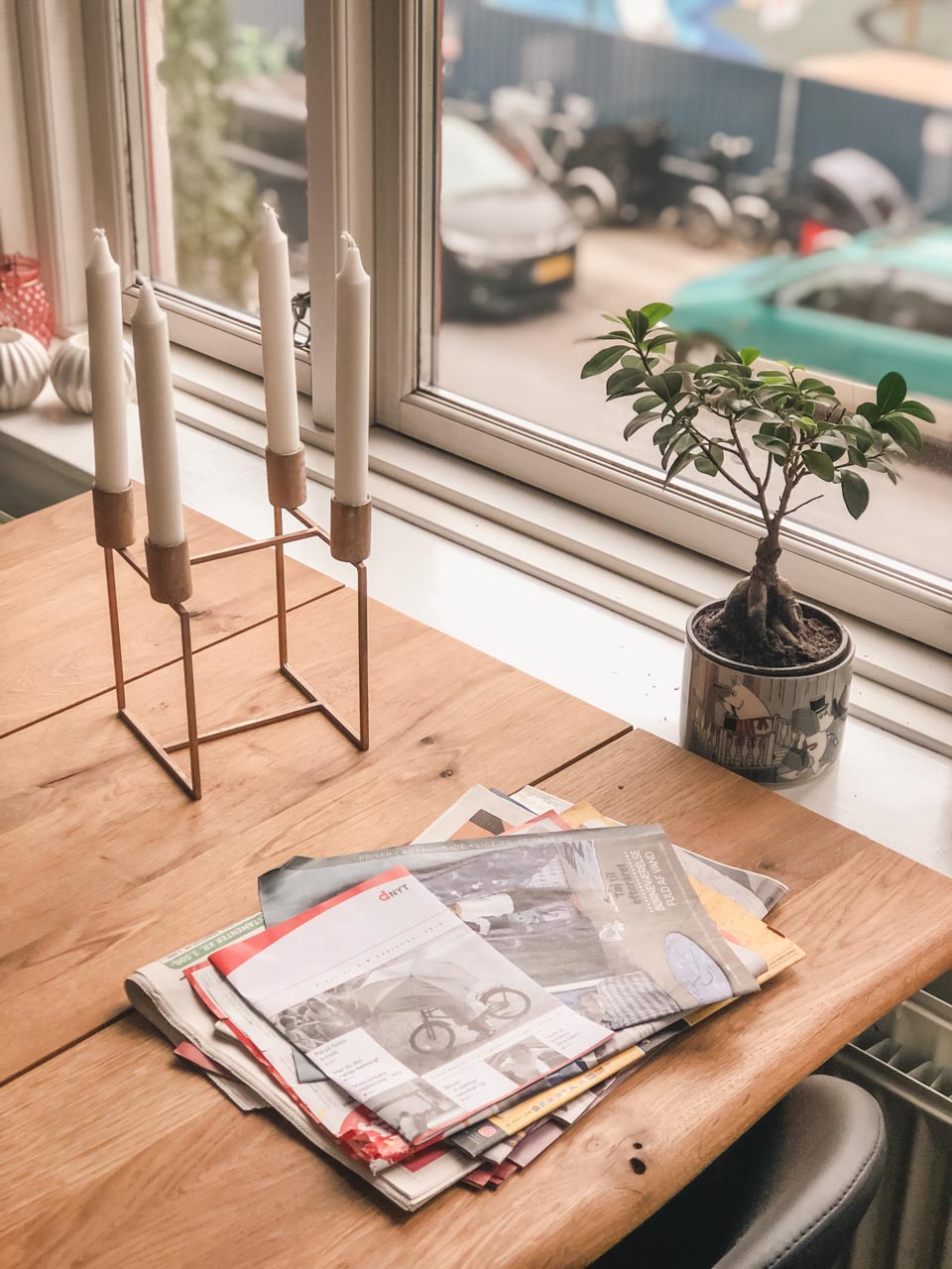 Some leaflets and a candle holder on a wooden table