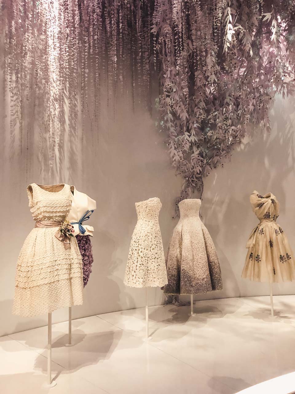 Dior gowns on display in the garden room of the Dior exhibition at the Victoria and Albert Museum
