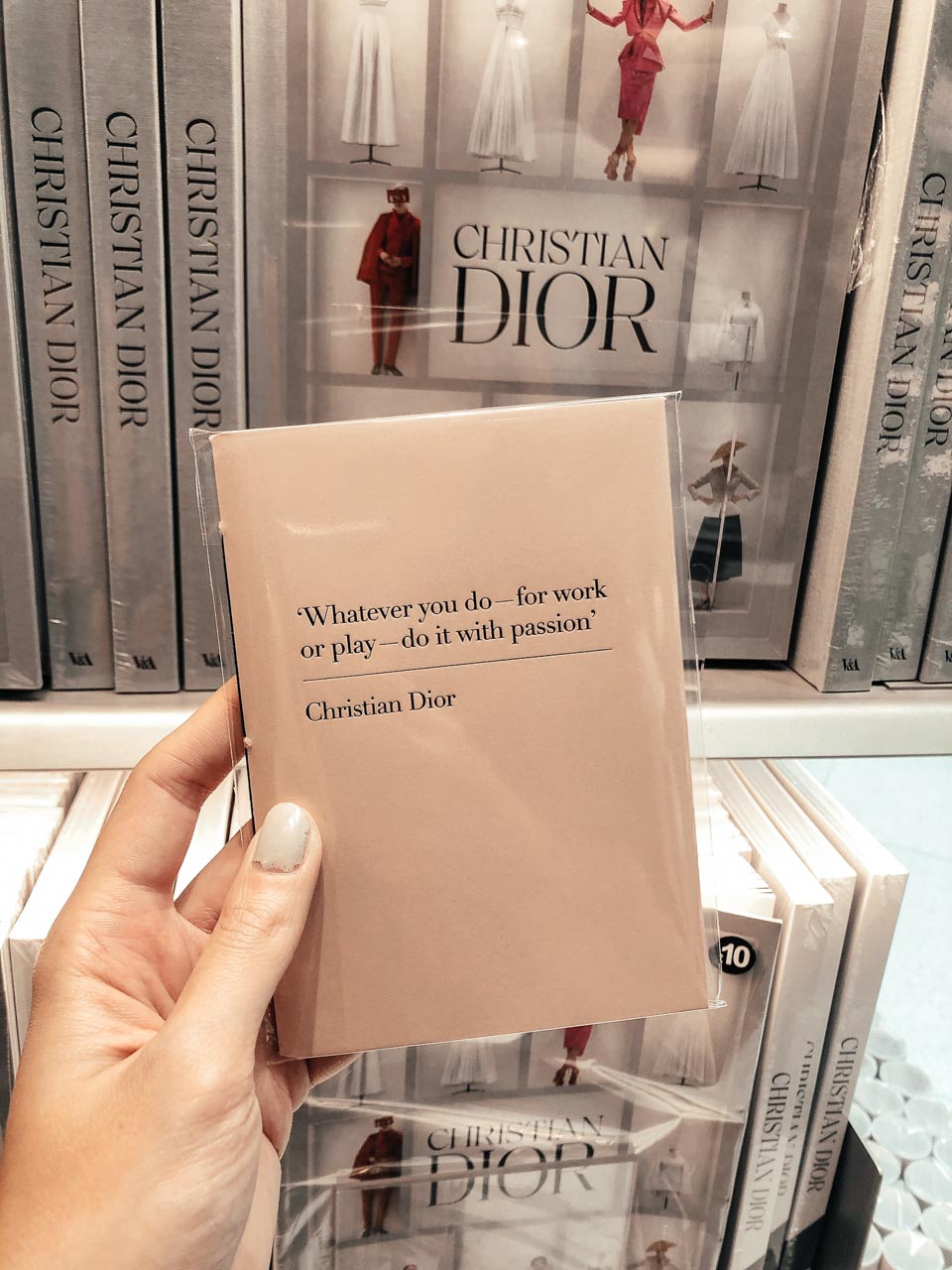 A girl holding a Dior notebook at the Victoria and Albert Museum in London