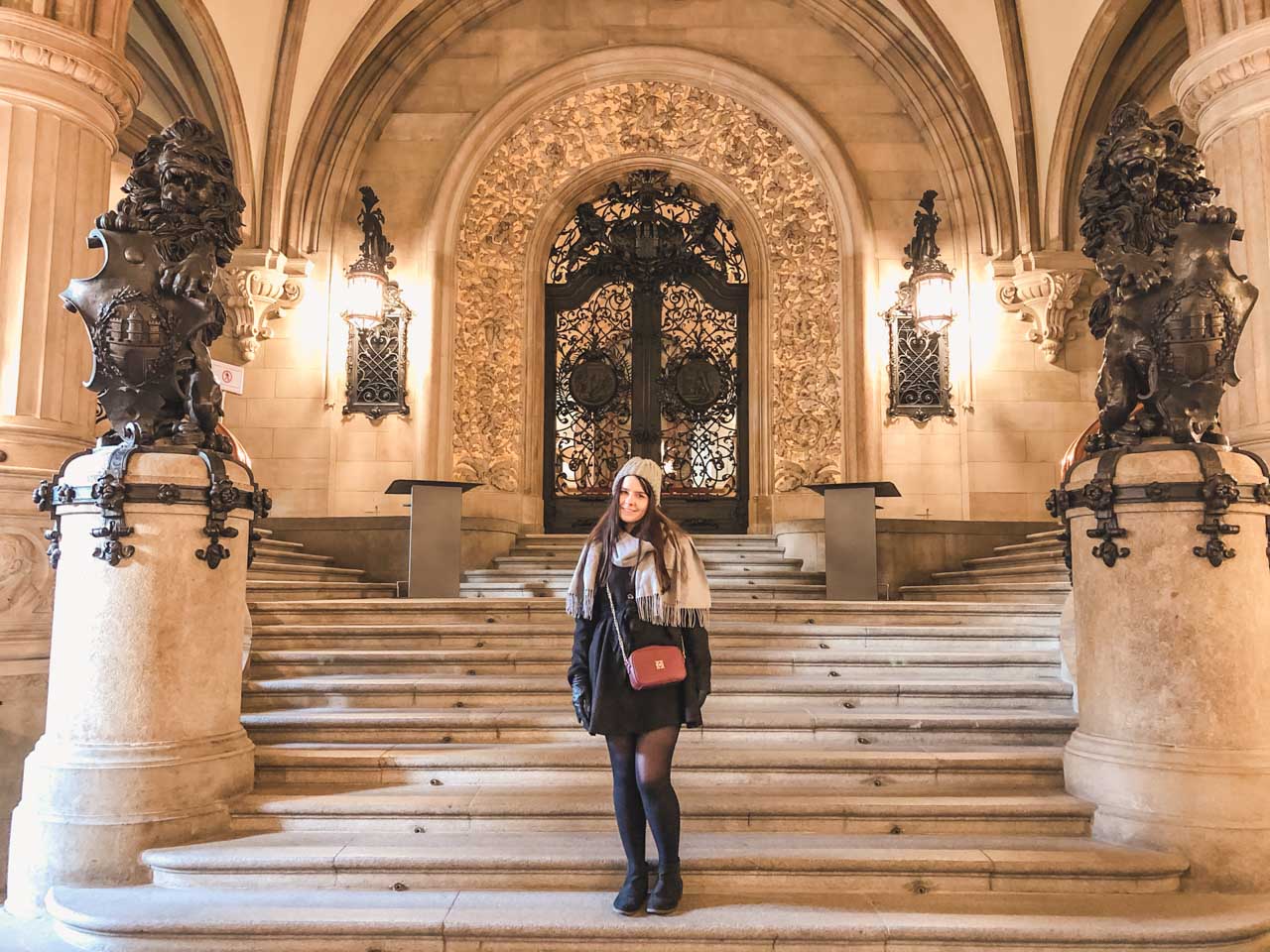 A girl in a black coat standing inside the City Hall building in Hamburg