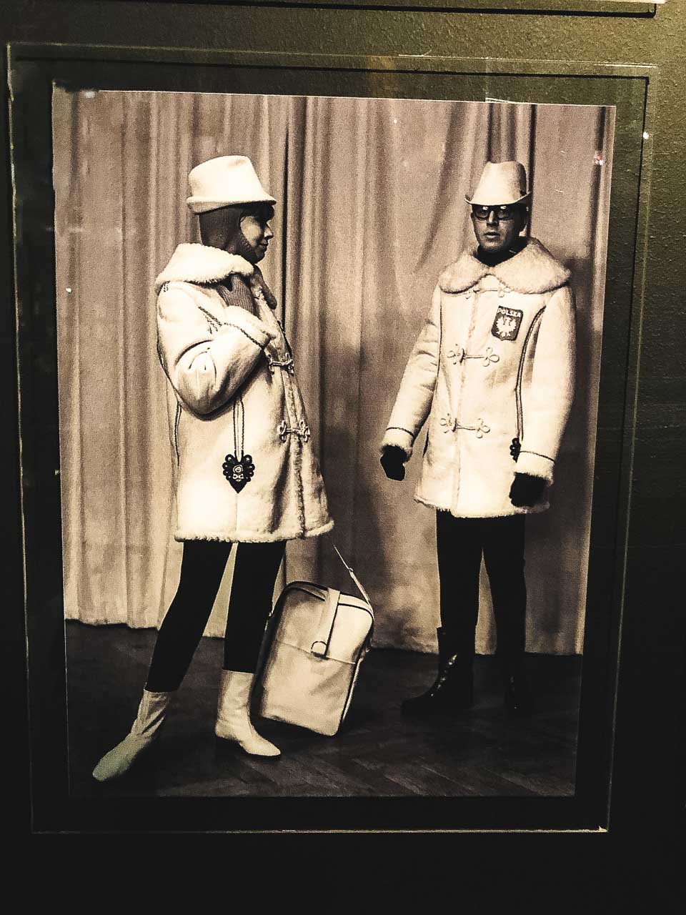 A photo of two people wearing clothes from the winter collection of Moda Polska on display at The Central Museum of Textiles in Łódź, Poland