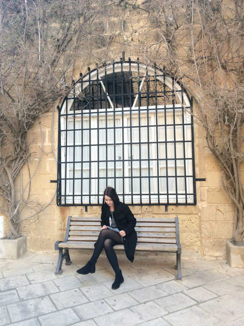 A girl sitting on a bench in Mdina, Malta