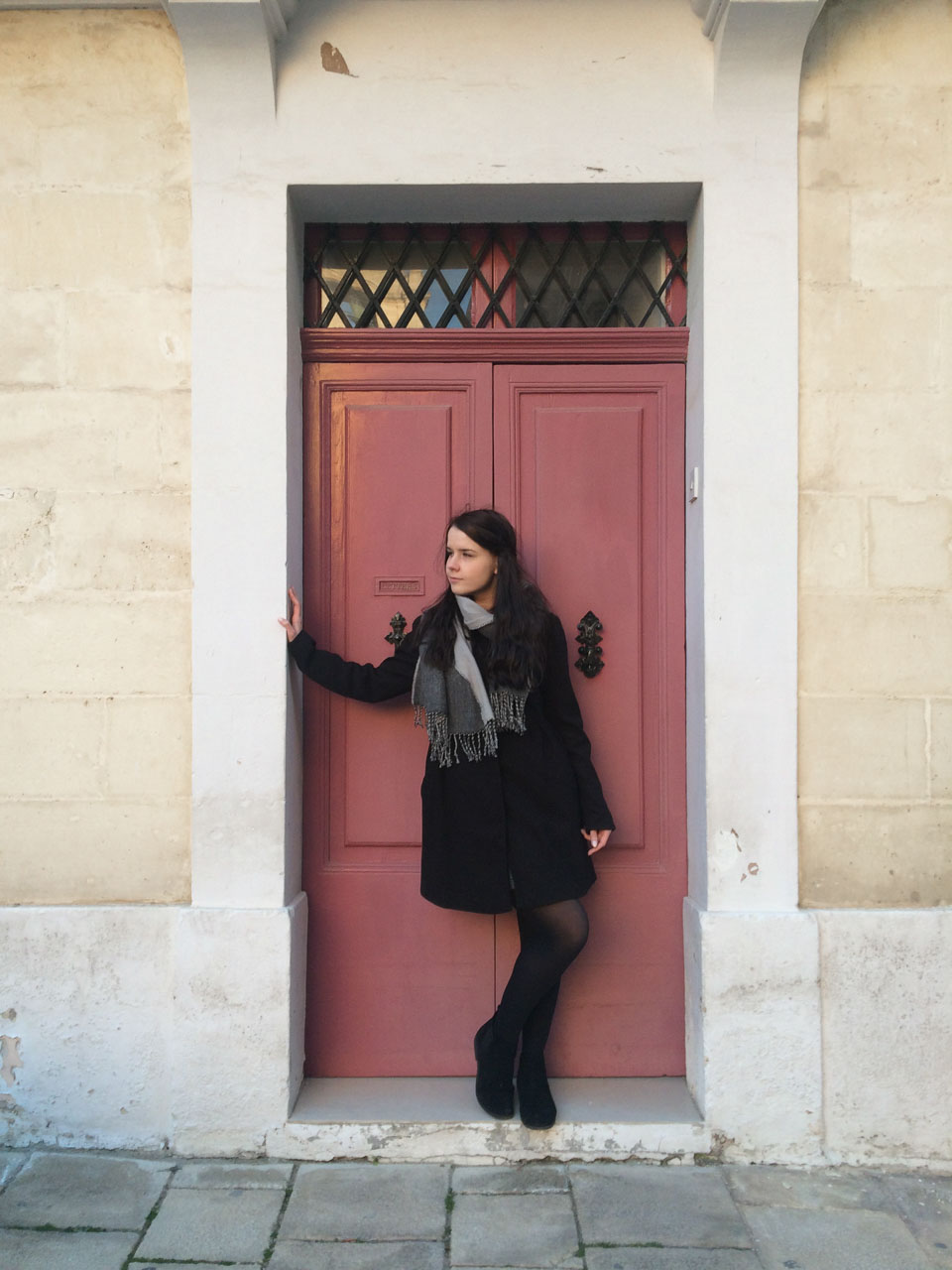 A girl standing in a colourful doorway in Mdina, Malta