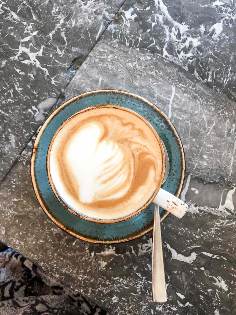 A cup of cappuccino on a black marble table 