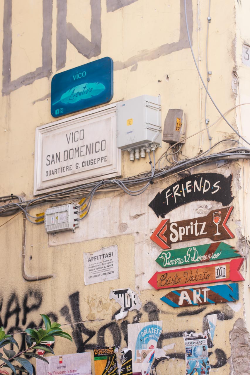 Street signs showing the directions to various bars and landmarks in Naples, Italy