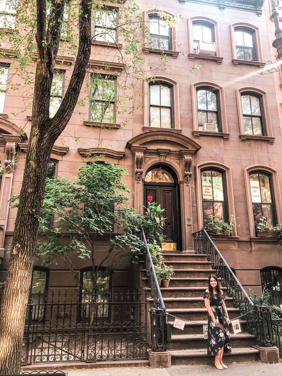 A girl in a maxi dress standing outside Carrie Bradshaw's apartment in New York City