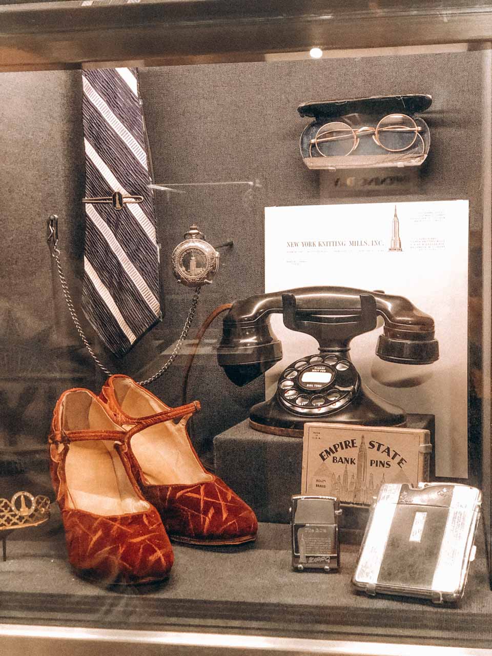 Vintage telephone and clothing items on display inside the Empire State Building museum