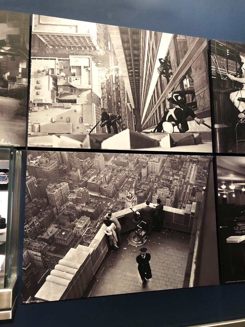 Old black and white photos hanging on the wall of the Empire State Building's museum