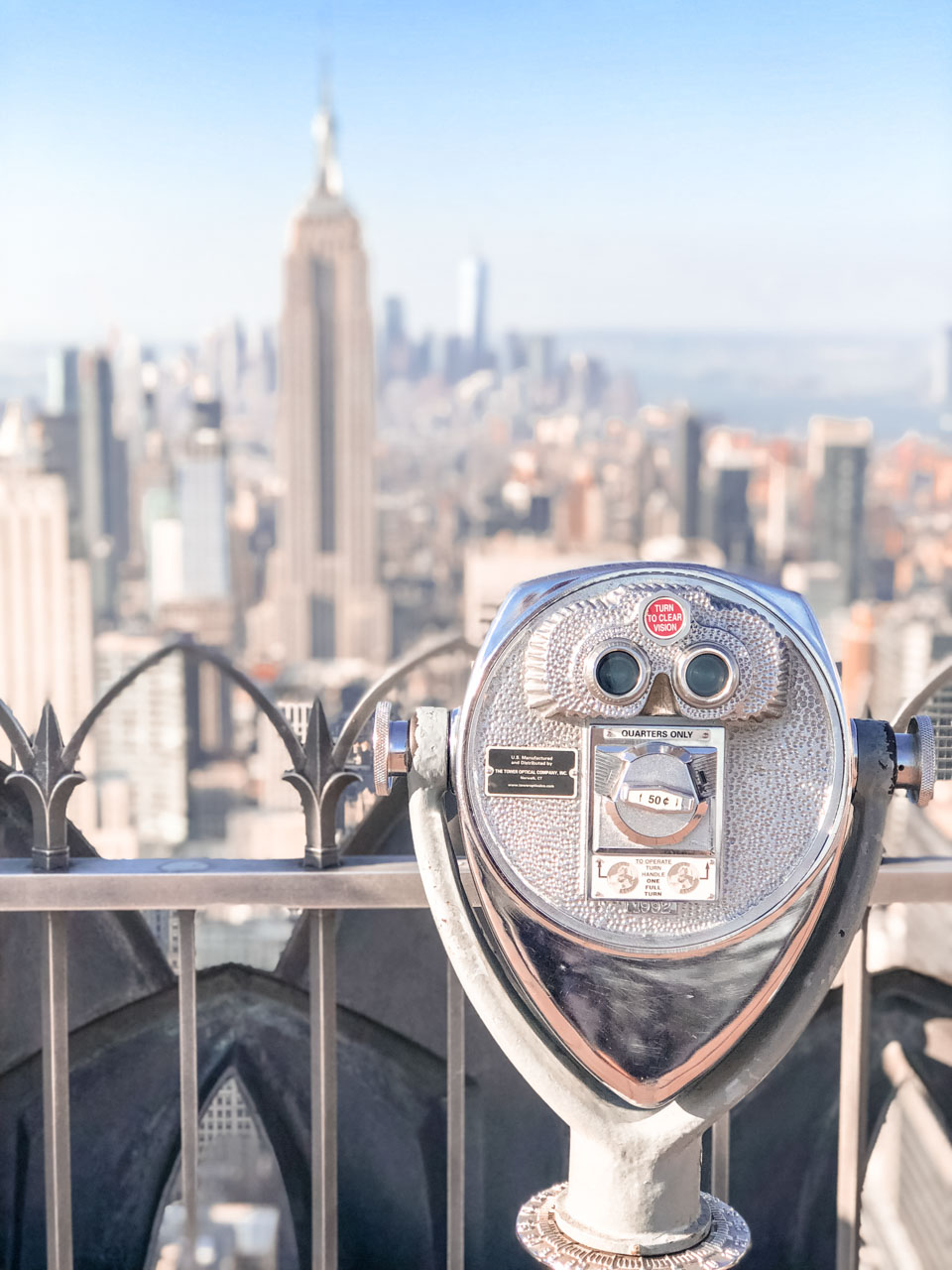 A close-up of the binoculars on Top of the Rock with the Empire State Building in the background