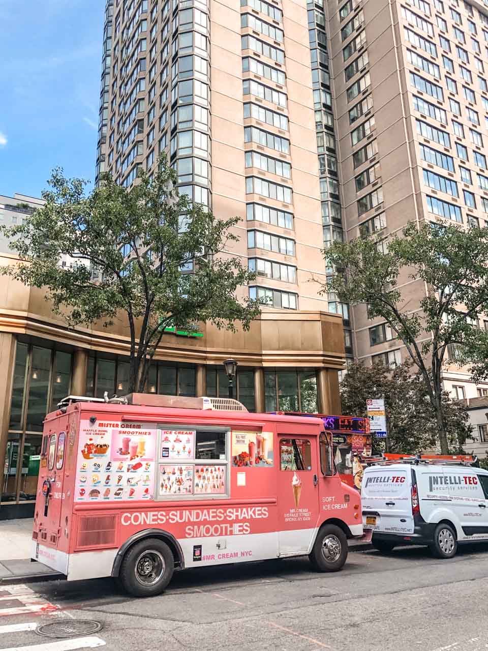 A colourful ice cream truck parked outside an apartment building in New York City