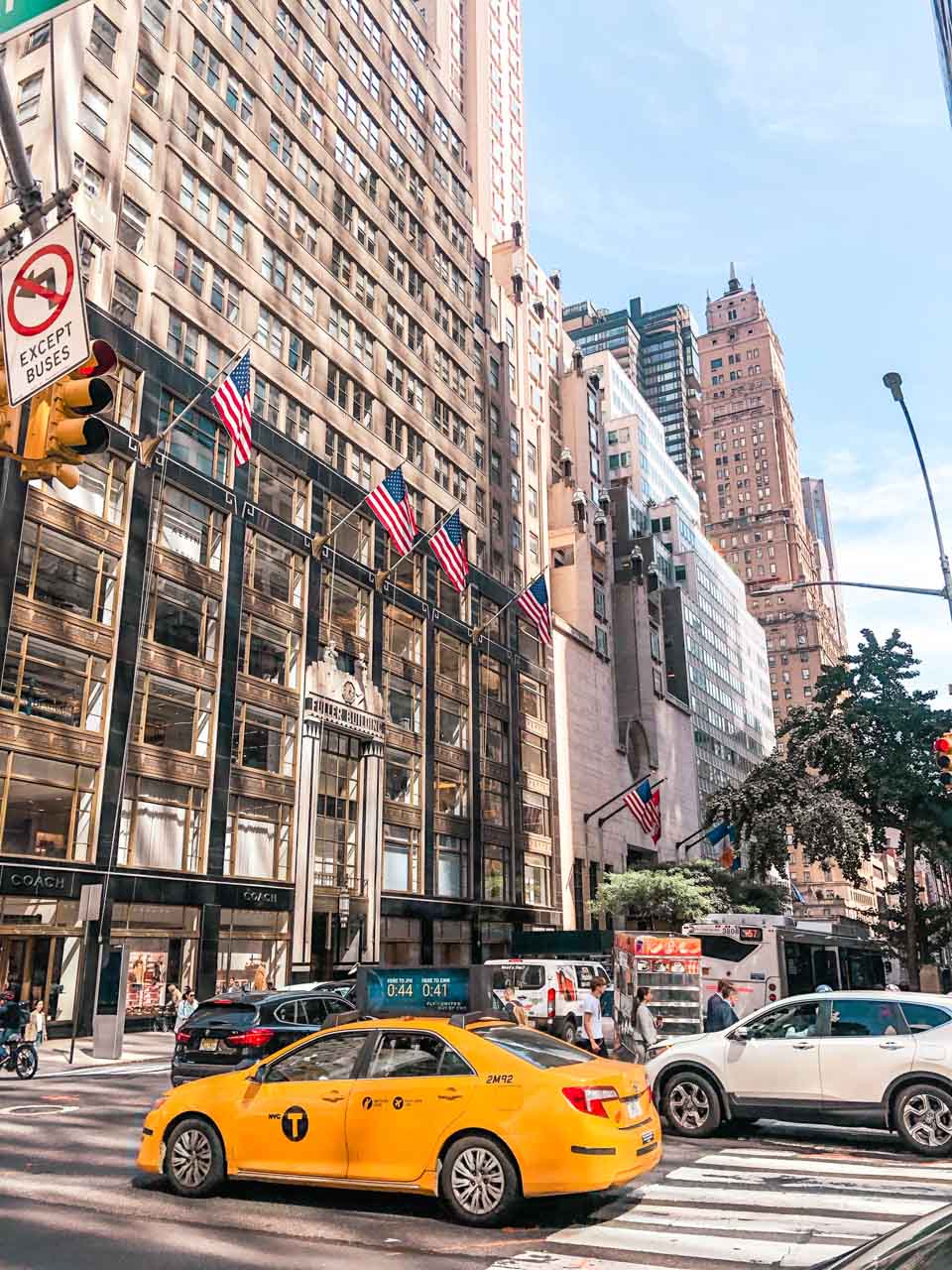 Yellow cab driving past Fuller Building in New York