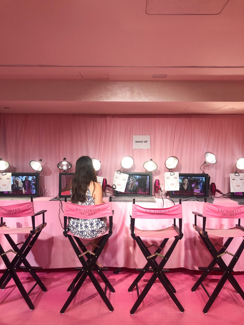 Girl in a patterned dress sitting in a makeup chair inside the Victoria's Secret Fifth Avenue store