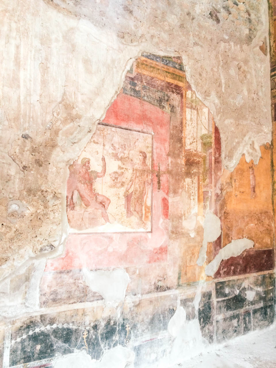 Old colourful paintings on the walls of a building inside Pompeii