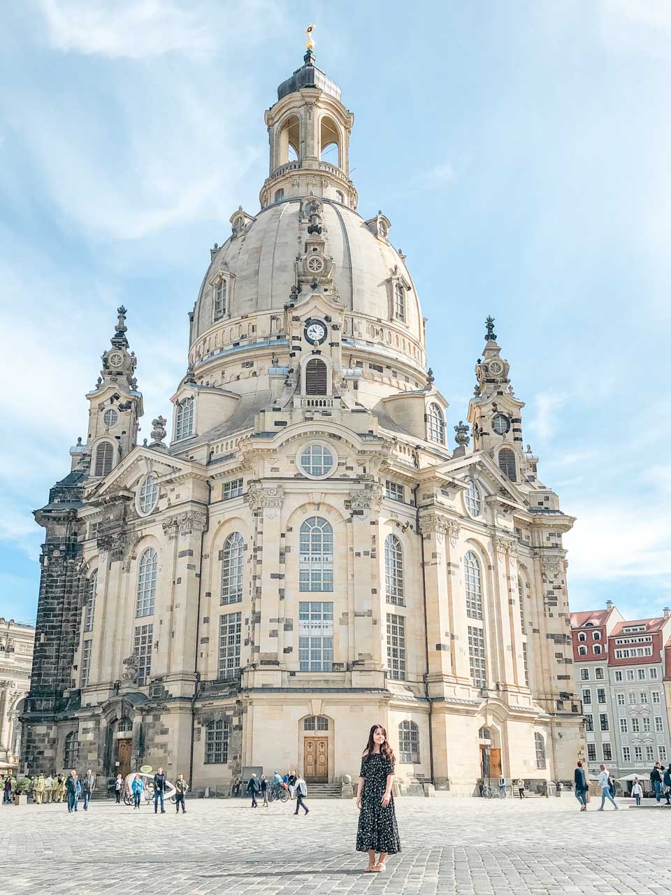 A girl in a maxi dress standing in front of the Frauenkirche in Dresden, Germany