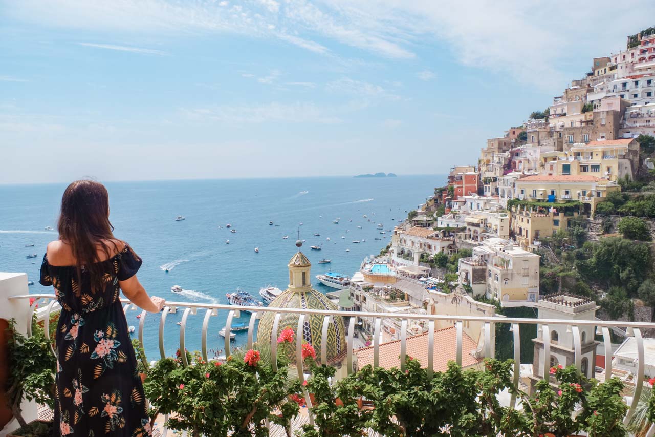 A girl in a floral dress standing on the terrace of Le Sirenuse Hotel in Positano