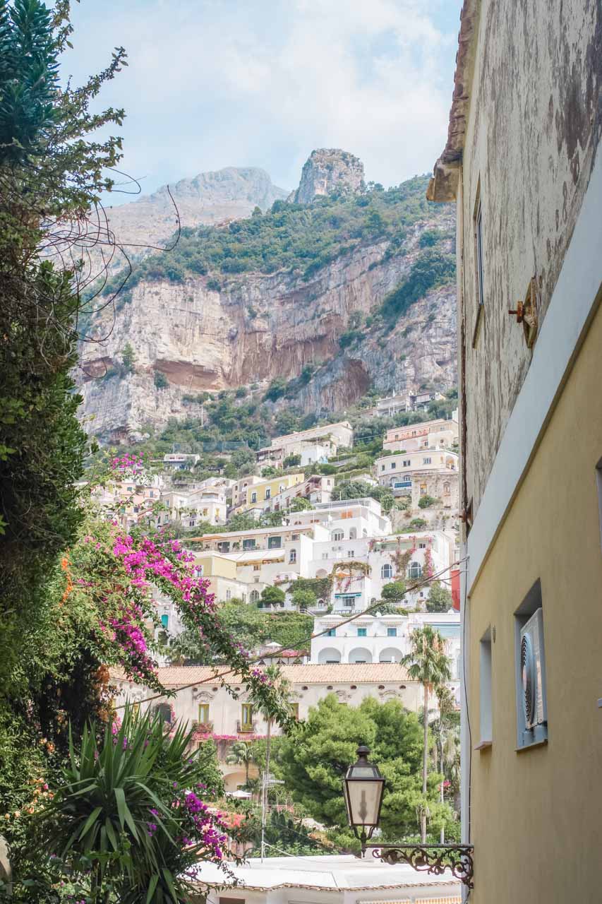 A view of the mountains and hillside houses from a narrow alley in Positano, Italy