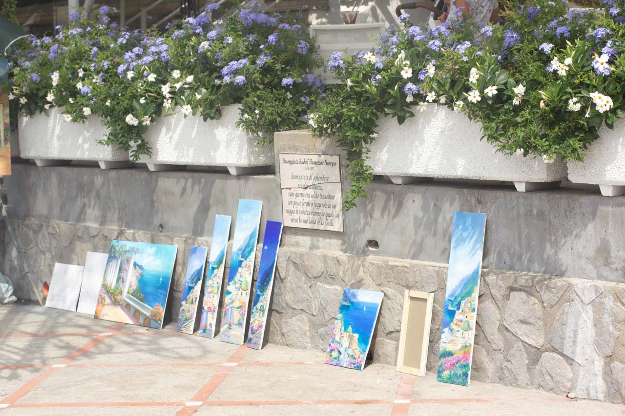 A stall with various watercolour paintings outside Spiaggia Grande in Positano, Italy