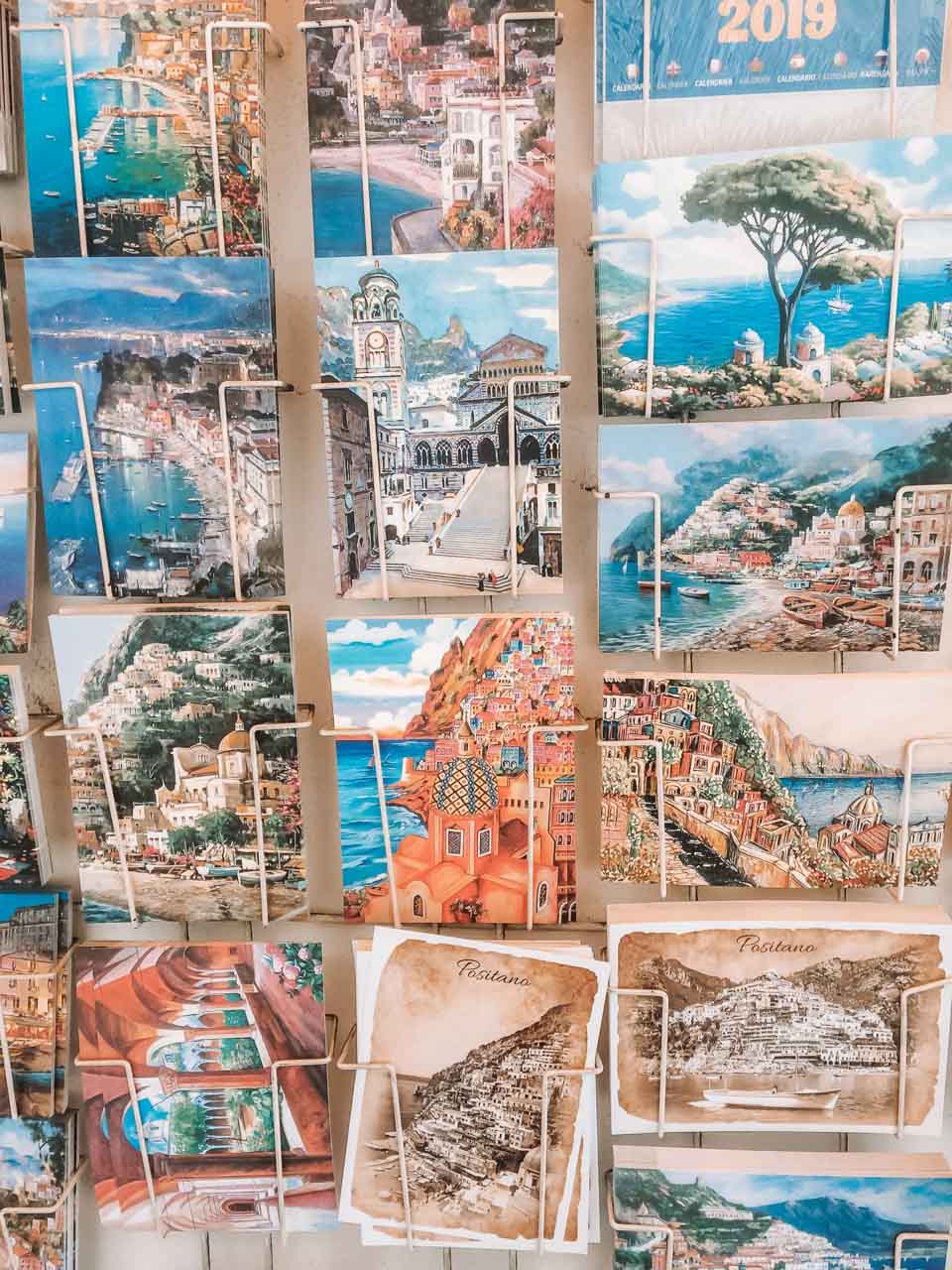 Various hand-painted postcards on display in Positano, Italy