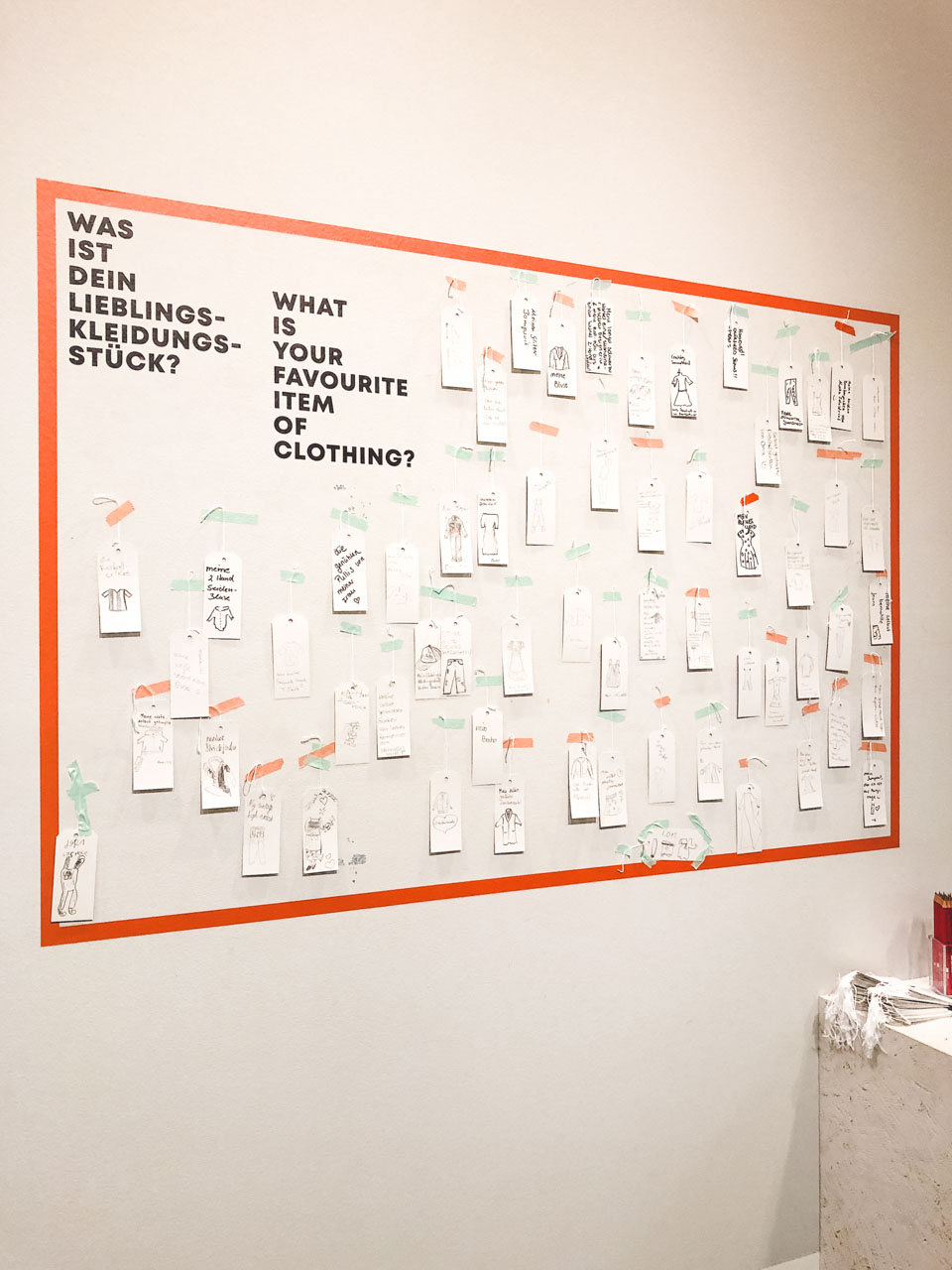 Wall with "What is your favourite item of clothing?" written on it and little hangtags with answers