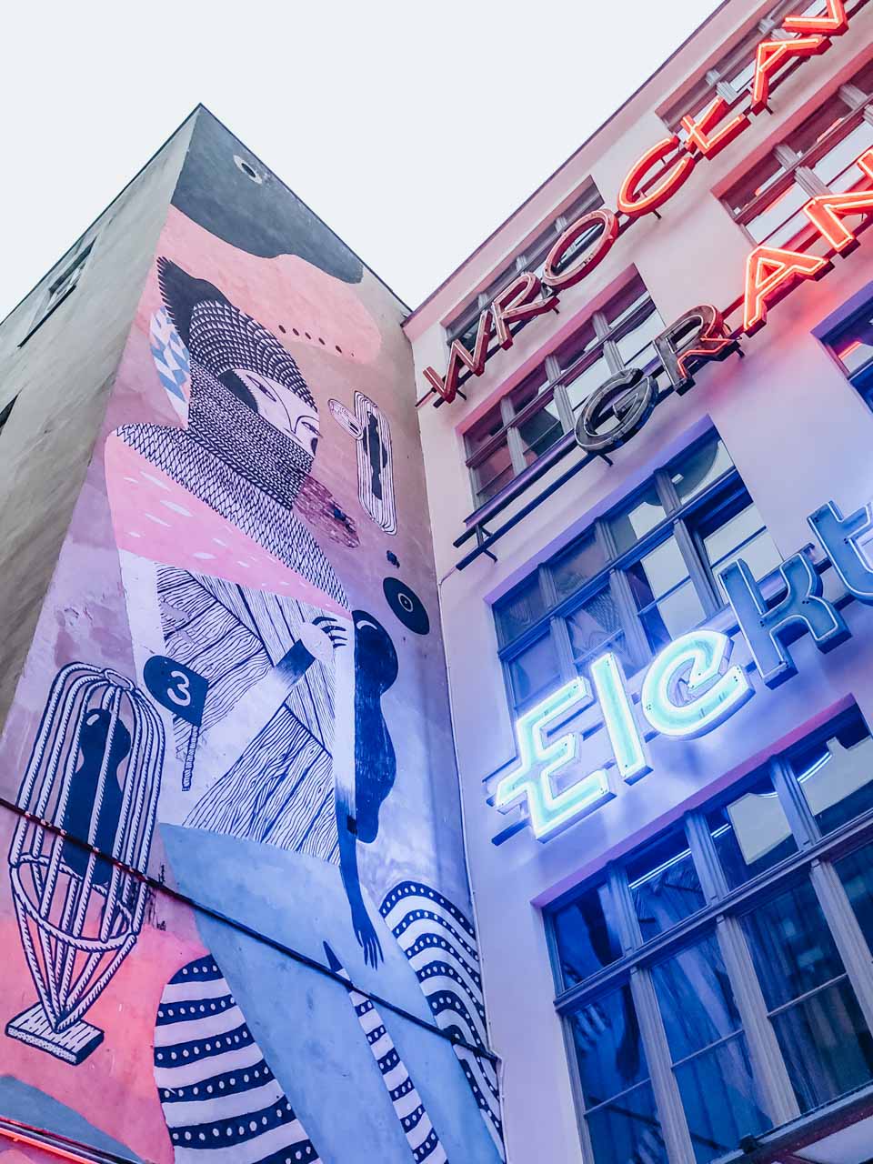 A mural and neon signs at the Neon Side Gallery in Wrocław