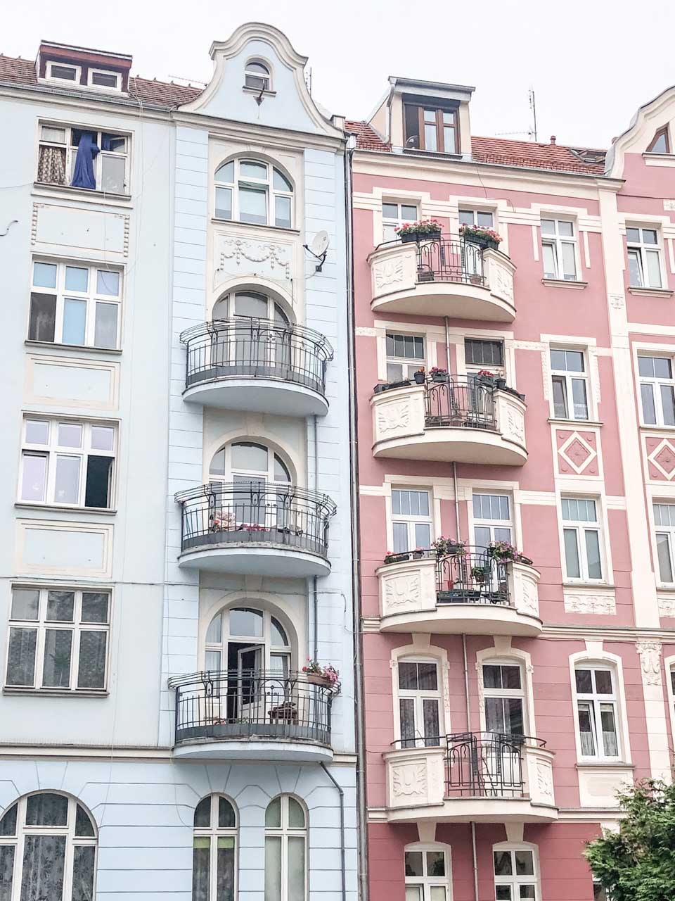 The exterior of two pastel blue and pink houses in Wrocław, Poland