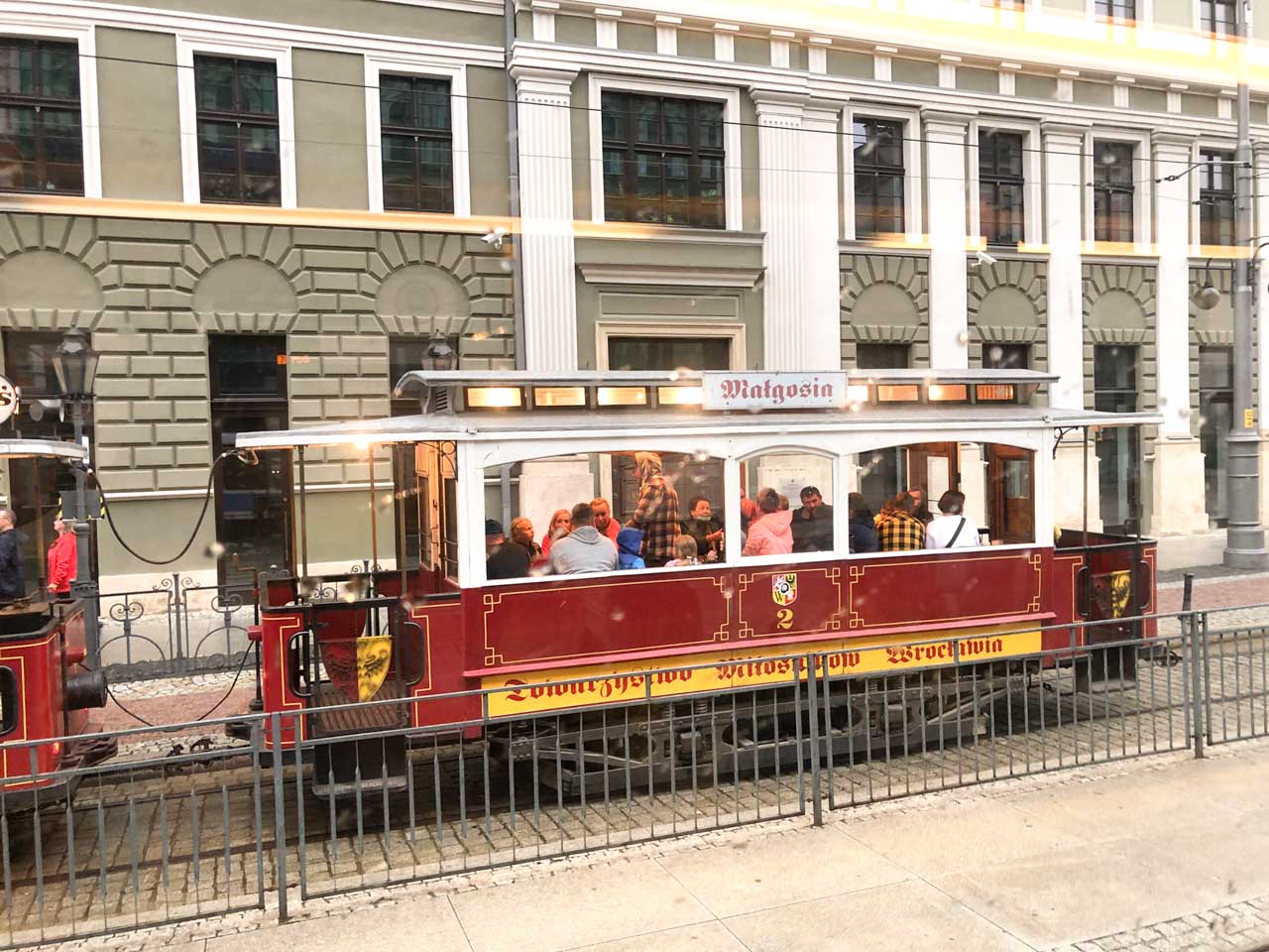A group of people sitting inside the historical Jaś i Małgosia tram in Wrocław