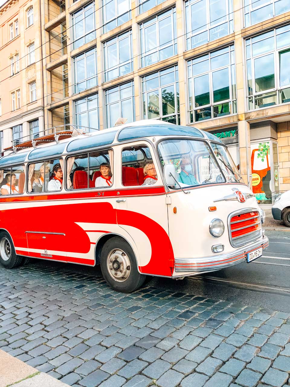A group of women inside a red and white vintage bus in Dresden, Germany