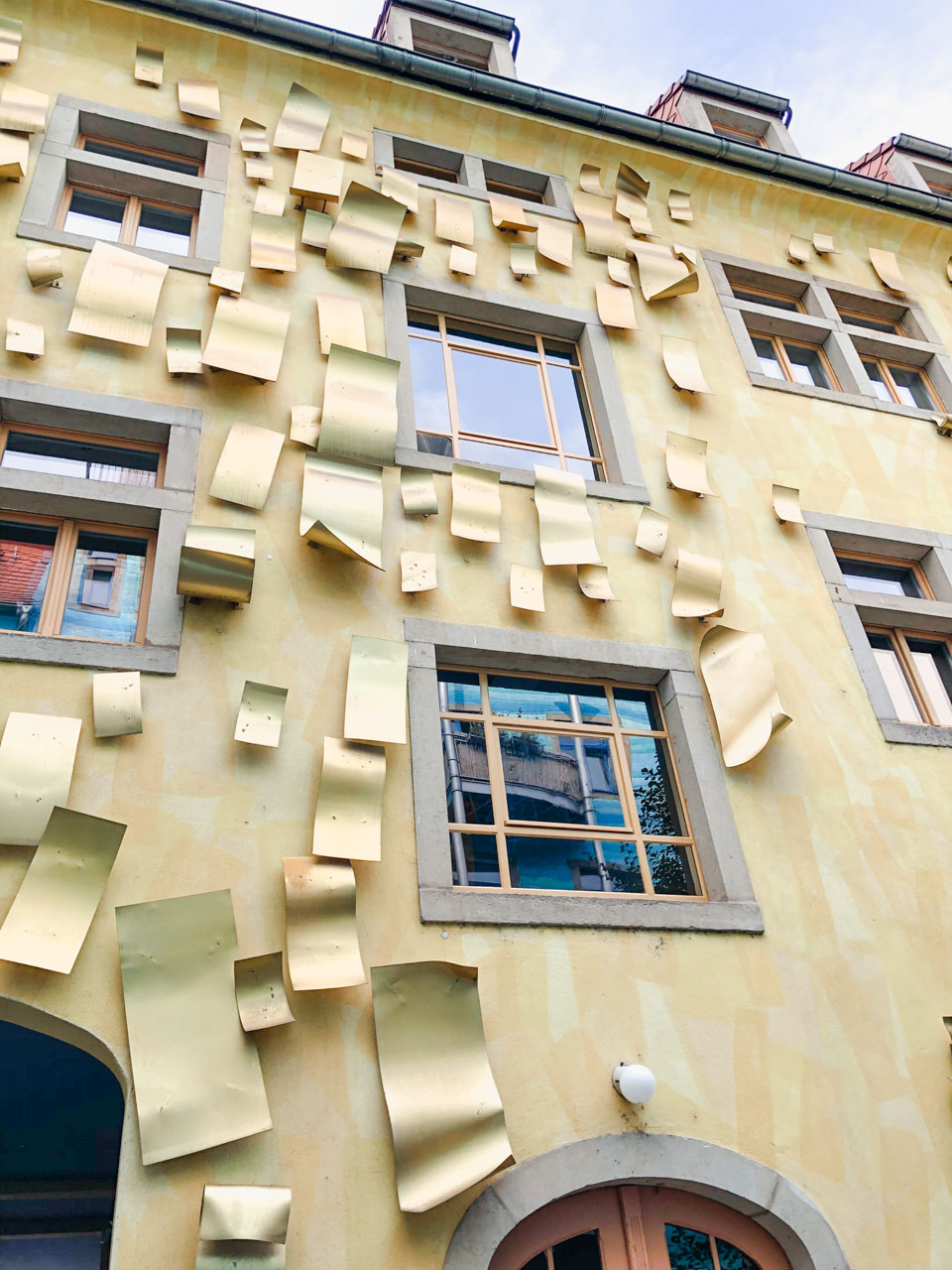 Metal mirrors on a yellow wall in the Courtyard of Light in Dresden's Kunsthofpassage