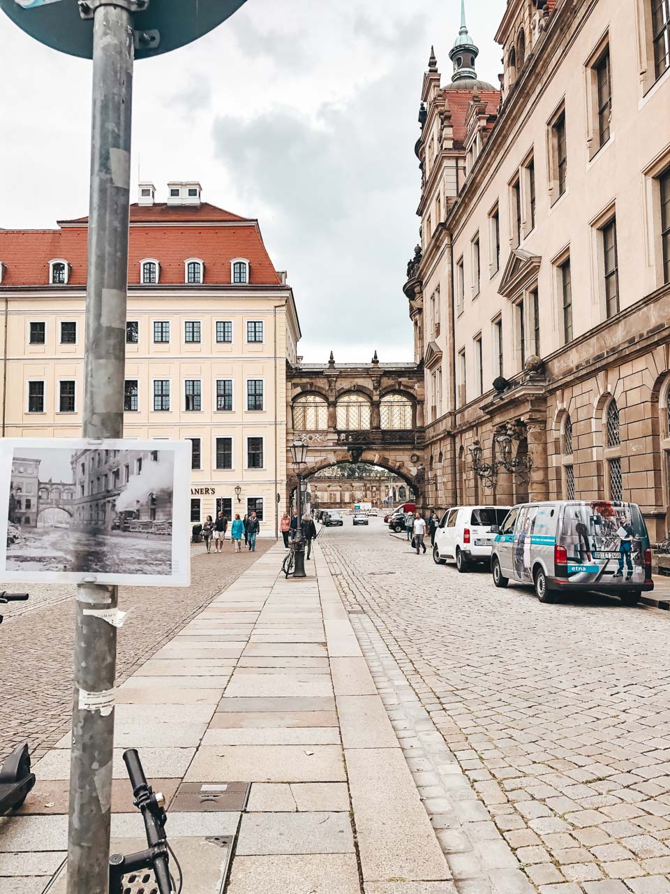 A pre-war black and white photo attached to a street sign across the road from Dresden Castle