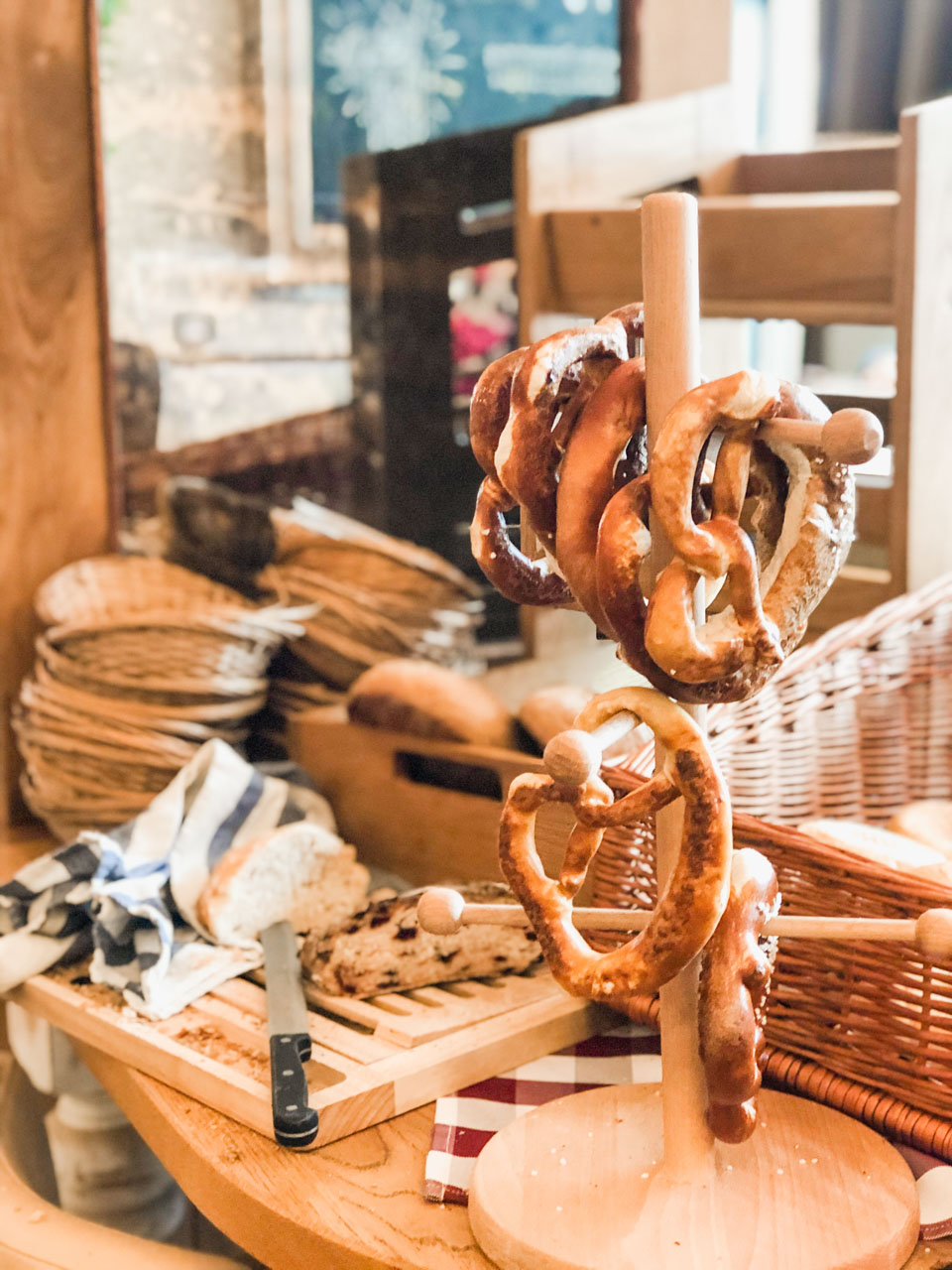 A wooden rack with hanging pretzels next to a chopping board at Alex in Dresden, Germany