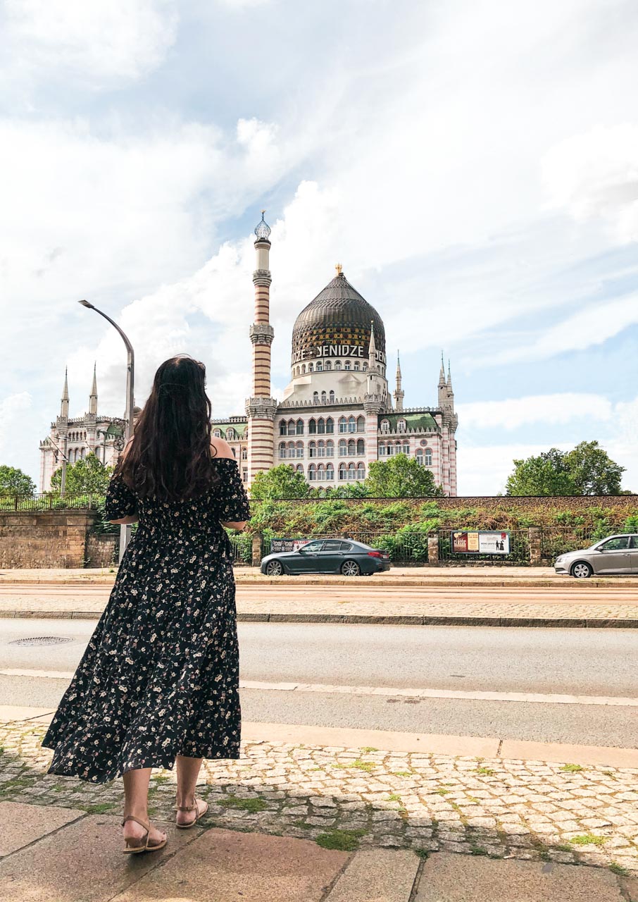 A woman in a black off-the-shoulder dress looking at Yenidze Cigar Factory in Dresden, Germany