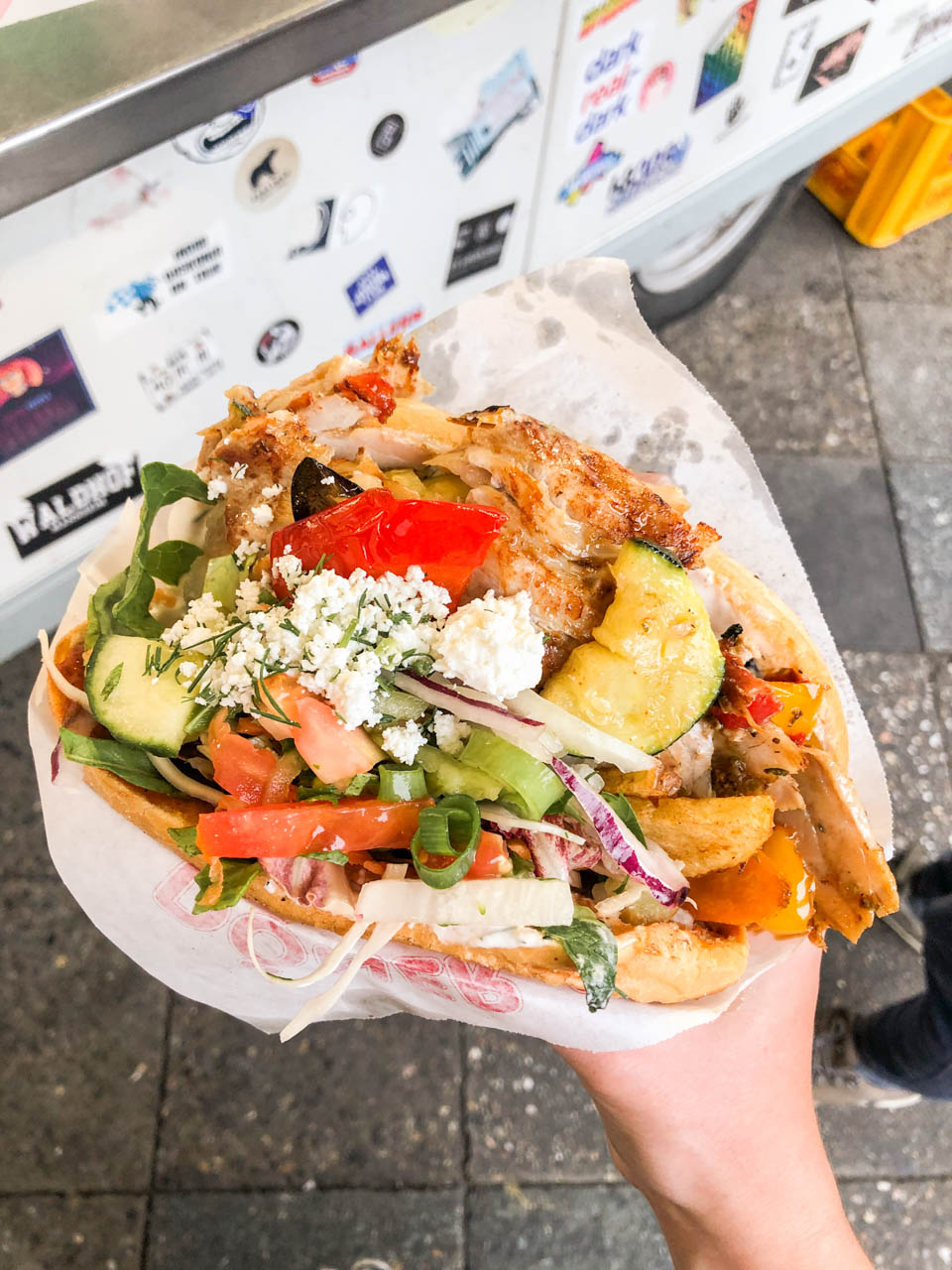 A woman's hand holding a kebab from Mustafa's Gemüse Kebap in Berlin, Germany