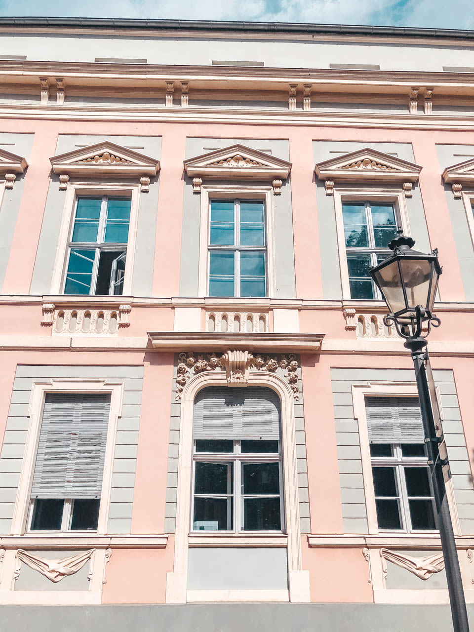 A street light outside a pastel pink tenement house in Potsdam, Germany