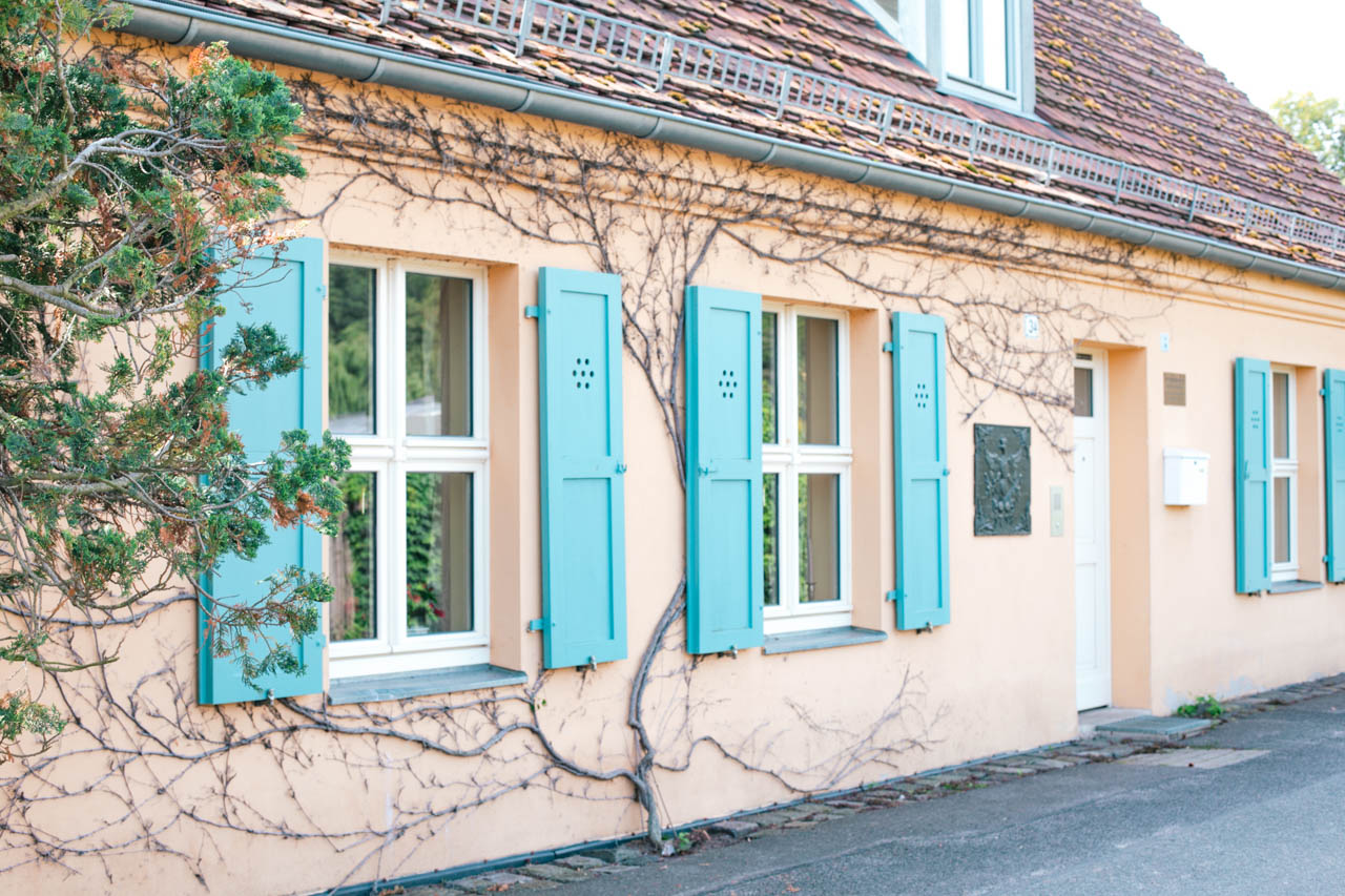 A yellow house with blue window shutters in Potsdam, Germany