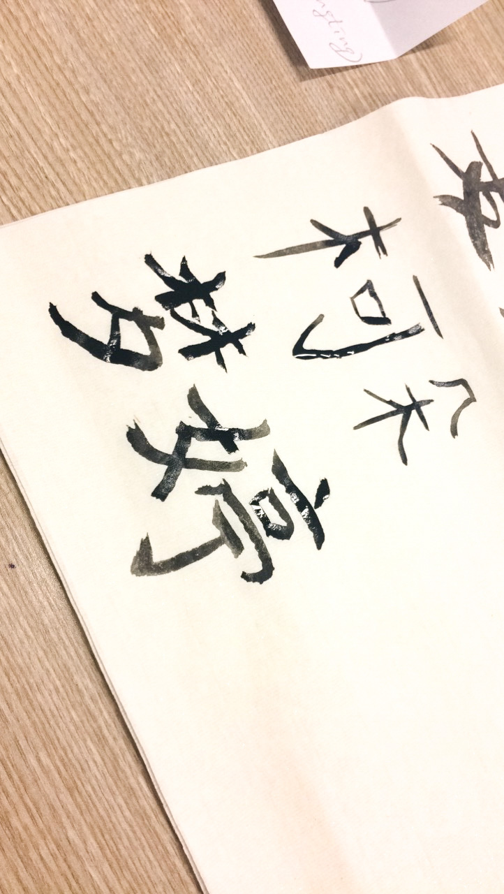 A close-up shot of various Chinese words written on special calligraphy paper