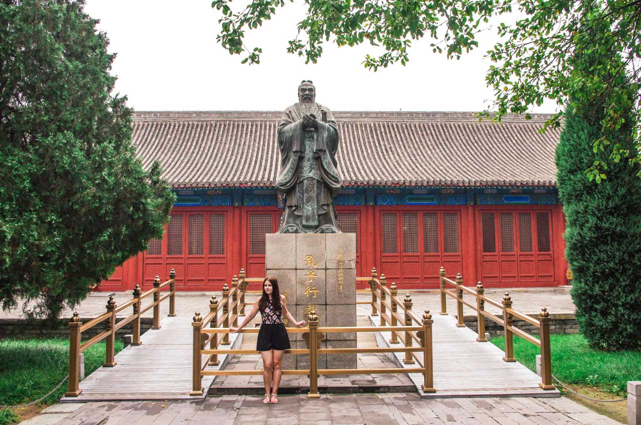 Woman standing in front of the statue of Confucius at the Temple of Confucius in Beijing, China