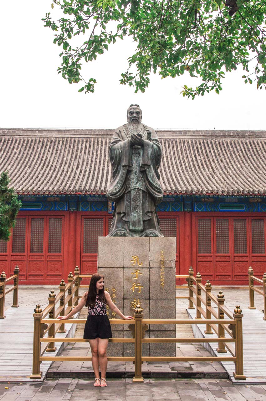 Woman standing in front of the statue of Confucius at the Temple of Confucius in Beijing, China