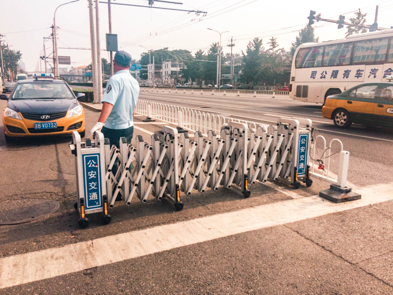Man blocking off a road with an expandable road block in Beijing, China