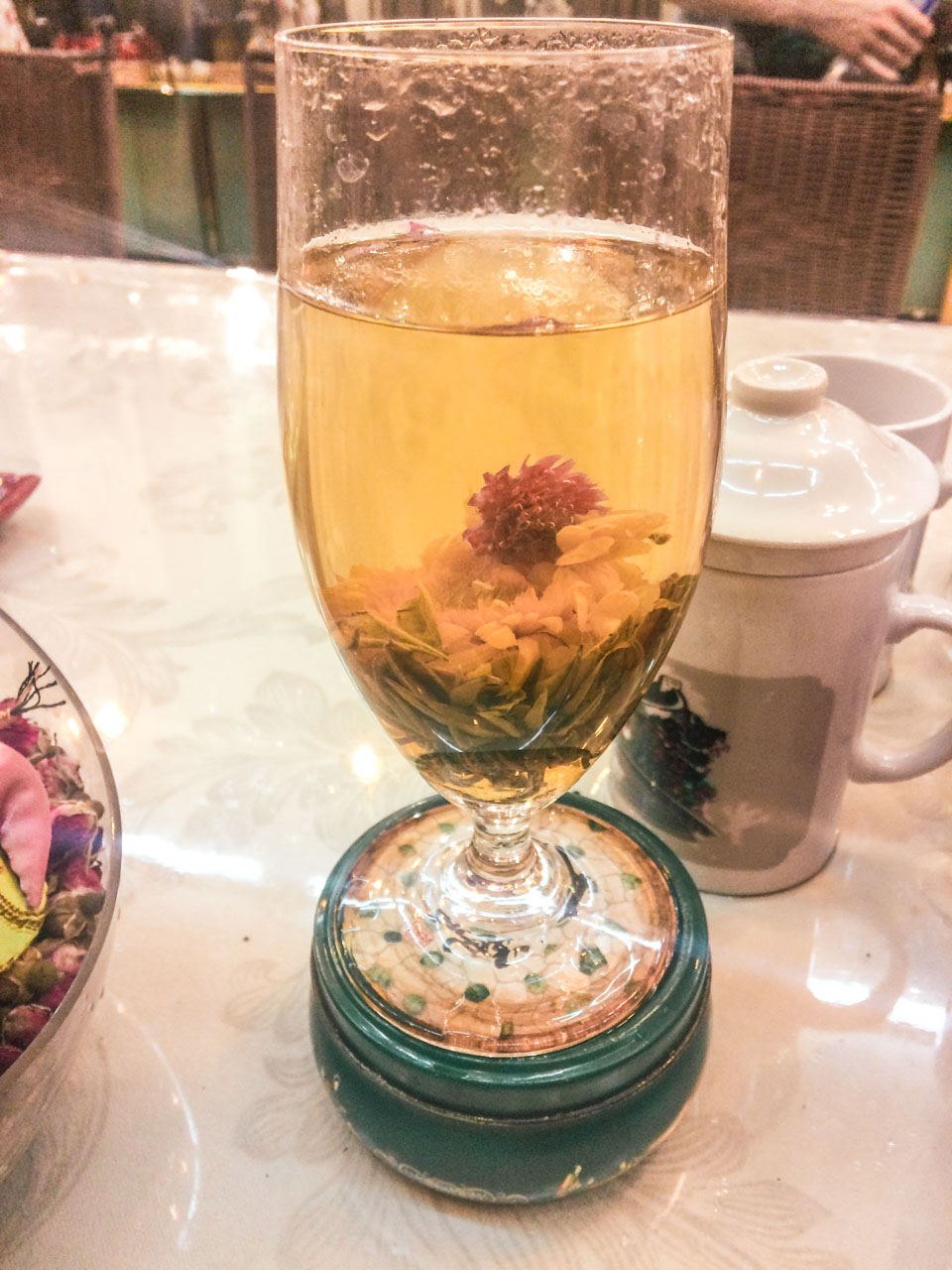 A close-up shot of flower blooming tea in a cup inside a traditional Chinese tea shop in Beijing