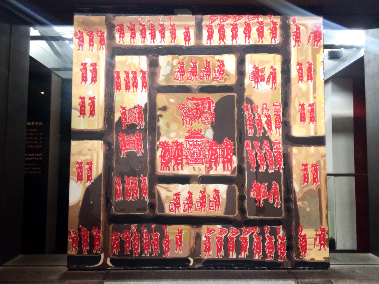 Golden plates with Chinese drawings on them reflecting the shadows of two people