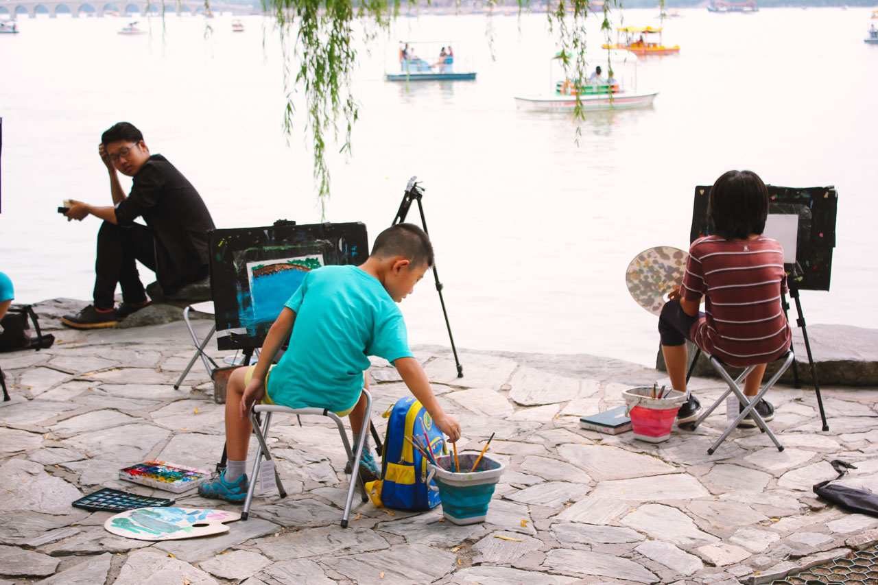 Young Asian children painting by the waterfront at the Summer Palace in Beijing, China