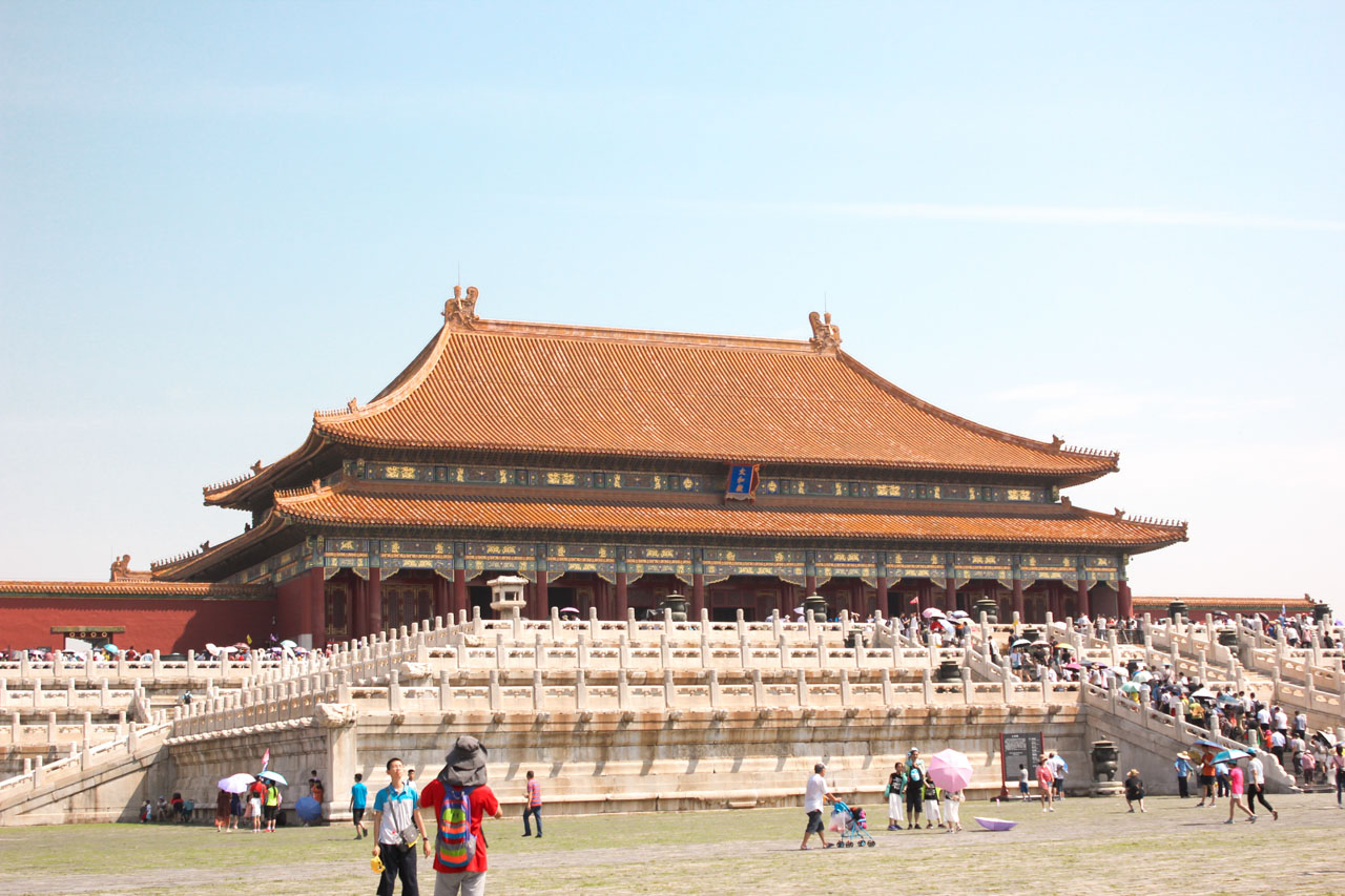 Crowds of tourists walking around temples at the Forbidden City in Beijing, China
