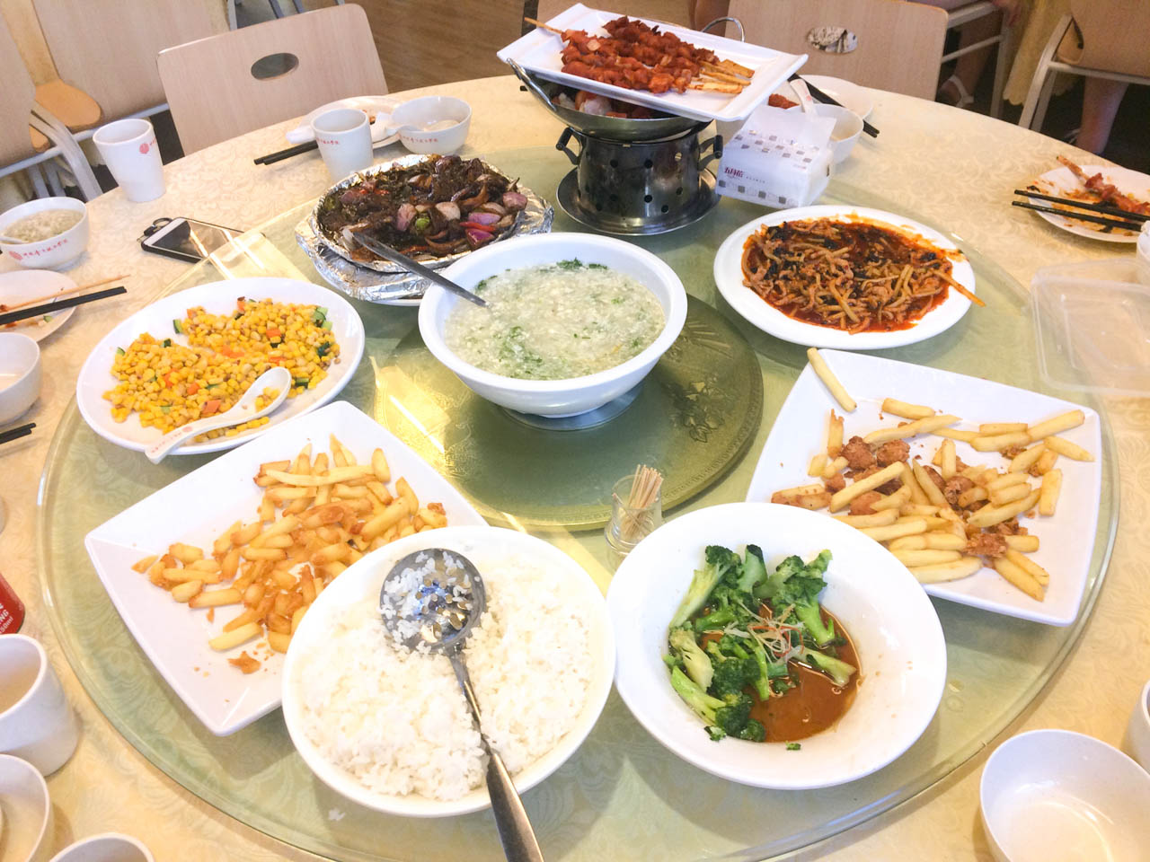 Chips, rice, and various Chinese dishes on a Lazy Susan rotating table