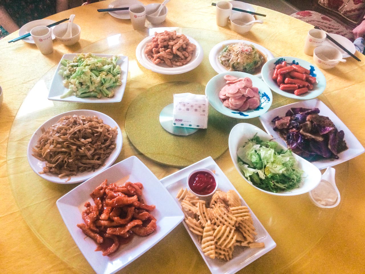 Waffle cut chips and various Chinese dishes on a Lazy Susan rotating table