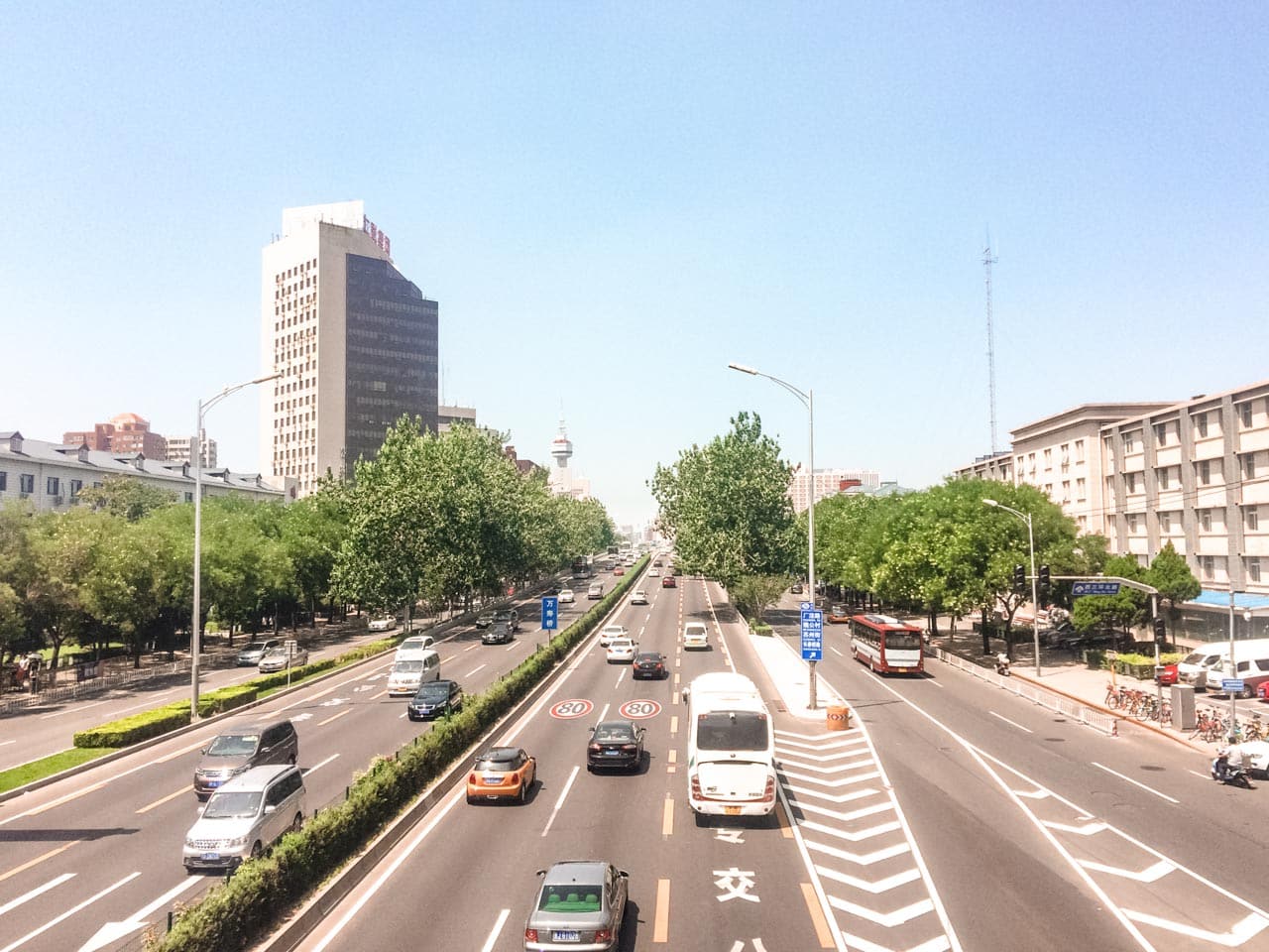 Cars and buses driving down a road in Beijing, China seen from above