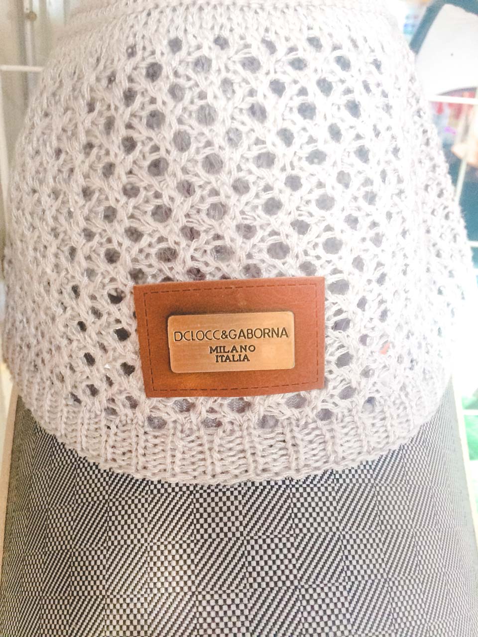 Crochet bucket hat with a metal plate saying "DClocc & Gaborna Milano Italia" at a shop in Beijing