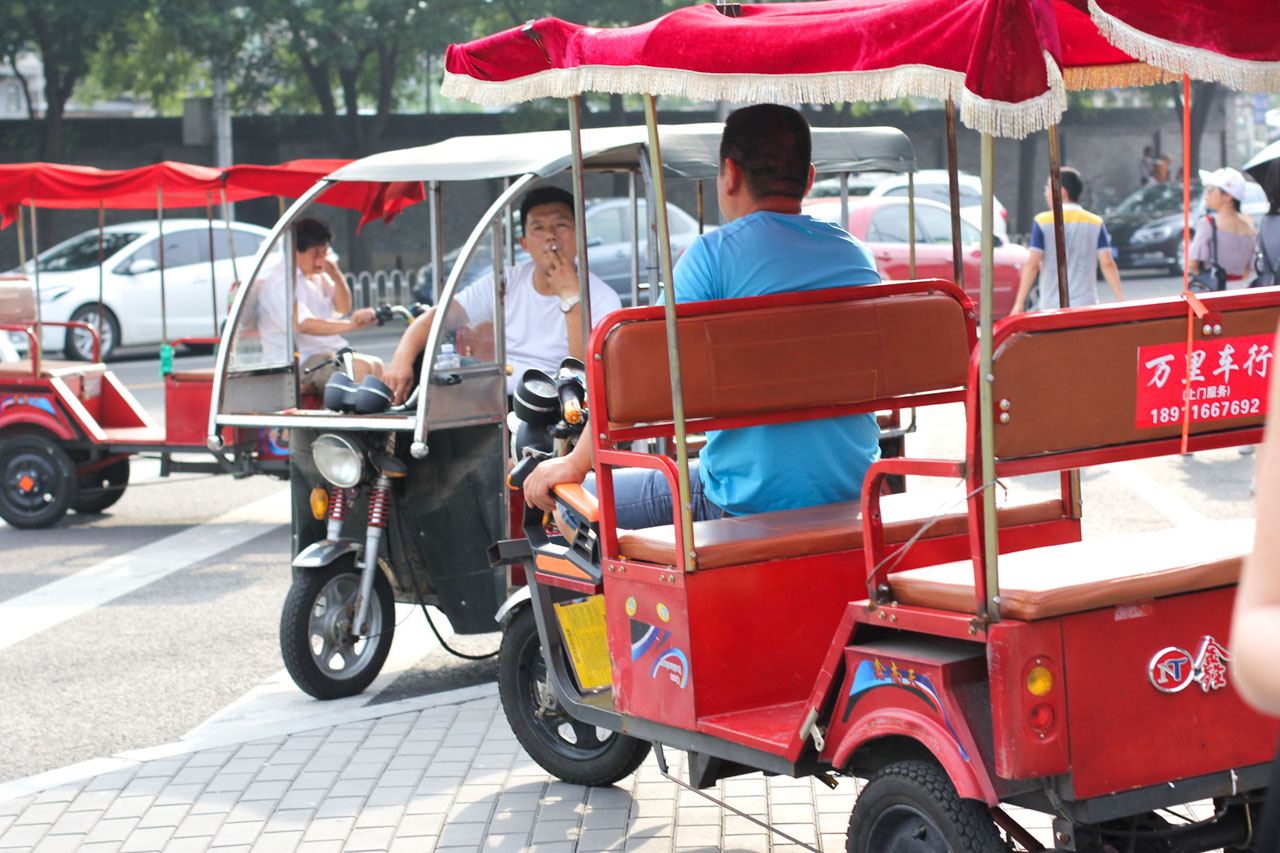 Chinese rickshaw drivers waiting for tourists outside the Bell and Drum Towers in Beijing, China
