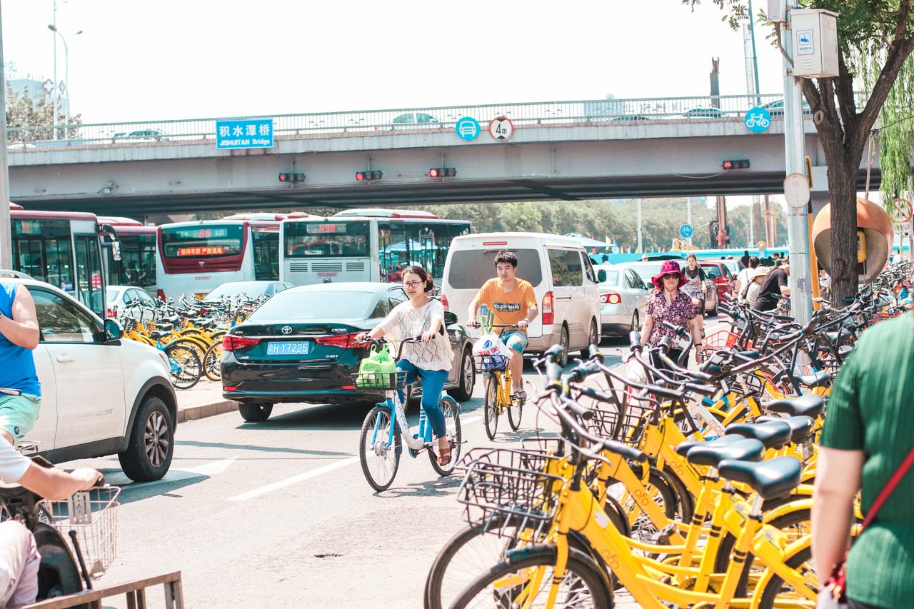 Asians cycling down a cycle lane next to a busy road in Beijing, China