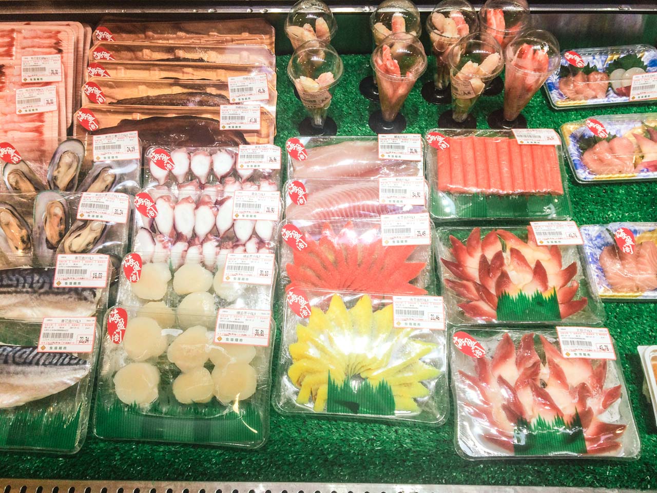 Various types of fruits, vegetables and seafood inside a display case at a supermarket in Beijing